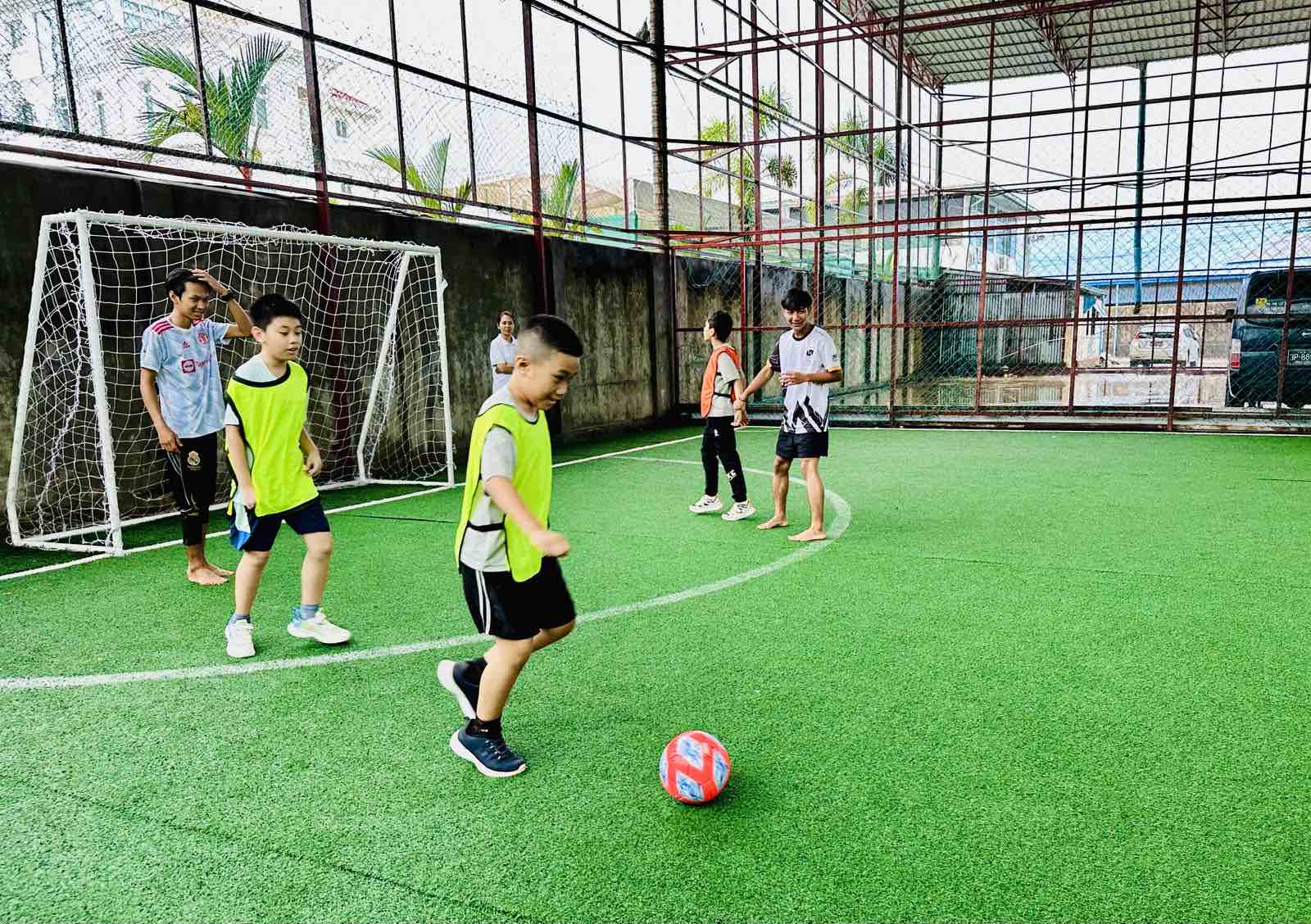 Children playing football on turf field